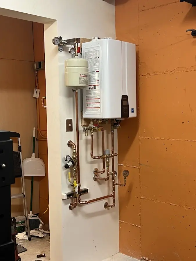 Plumbing technician inspecting water heater connections in Cedar Mill